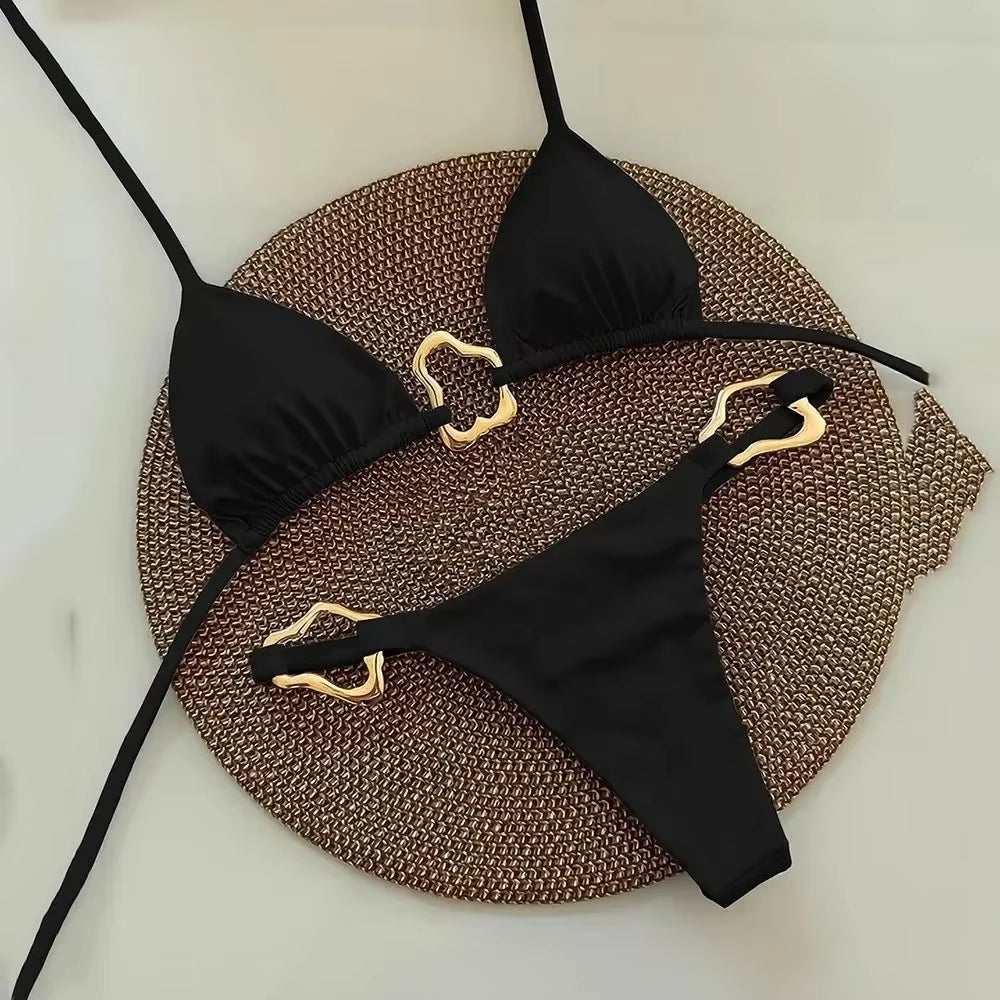 Sleek black halter triangle micro bikini set with gold accents on a woven background, perfect for summer swimwear.