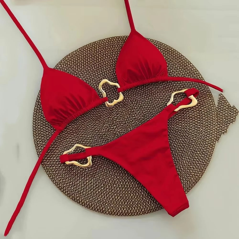 Sleek red halter triangle micro bikini set displayed on a textured round mat, perfect for swimwear trends 2024.